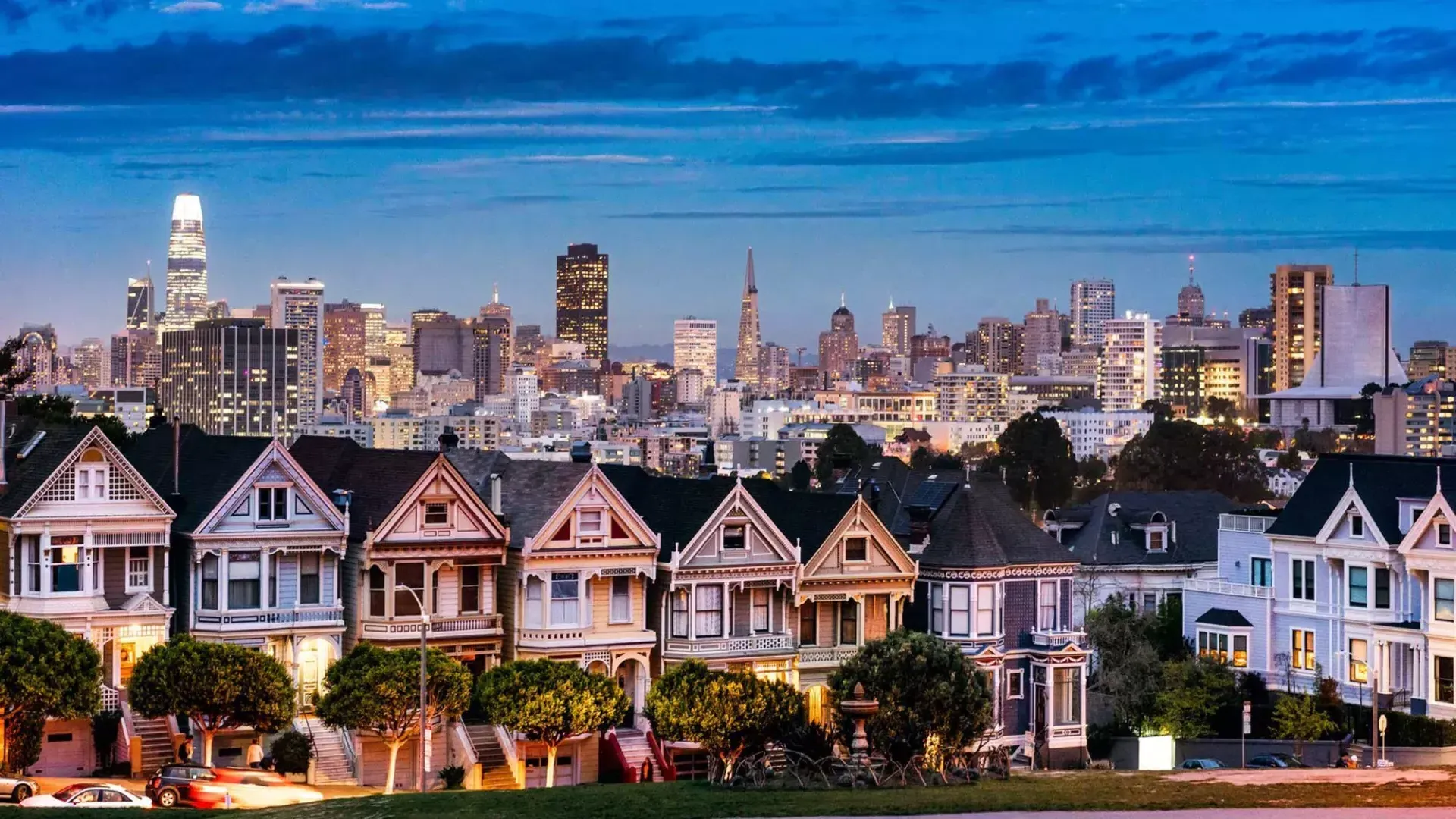 Las famosas Damas Pintadas de Alamo Square aparecen fotografiadas ante el horizonte de San Francisco al anochecer.